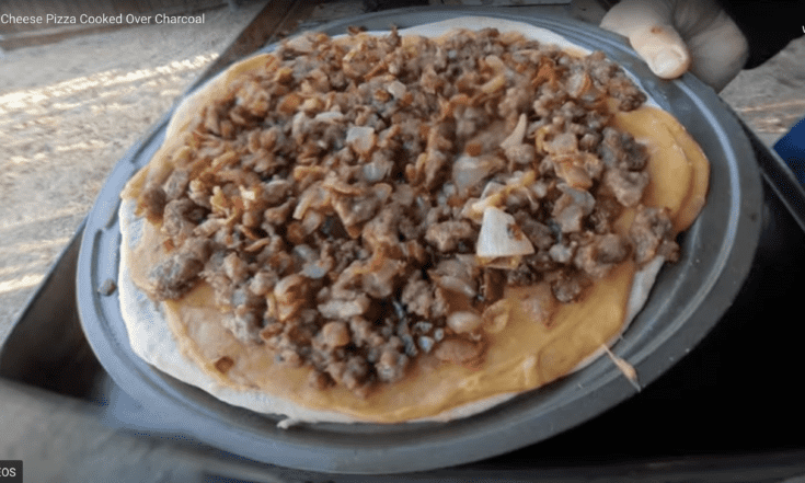 Beer Cheese Pizza with sausage, bacon and onions as toppics.